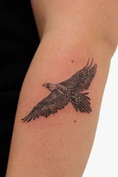 a tattoo on the arm of a woman with an eagle in it's wings