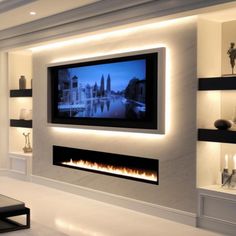 a living room with a large television mounted on the wall and lit up by candles