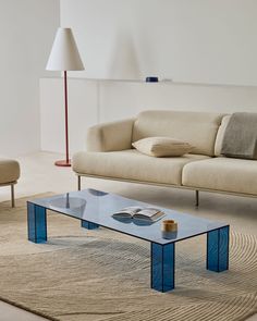 a living room with a couch, coffee table and lamp in it's center