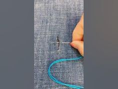 someone is stitching something on the side of a piece of fabric with a needle