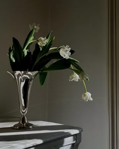 a vase filled with white flowers on top of a table