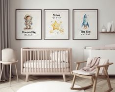 a baby's room with three posters on the wall and a rocking chair next to it