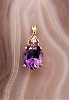 CJ80498AM Maine amethyst pendant. 14k yellow gold pendant mounting set with amethyst and diamond accent. Amethyst is 2.6cts, approximately 10x8mm. This stone is from the famous Fourth of July Amethyst discovery in Stow, Maine. This stone was mined in 1993 by Intergalactic Mining Corp. Diamond is round brilliant cut, approximately 1.8mm, SI clarity. Amethyst Pendent Designs, Stone Pendants Gold, Amethyst Jewelry Necklace, Amethyst Earrings Studs, Teapot Necklace, Amethyst Ring Vintage, Fancy Jewelry Necklace, Pretty Jewelry Necklaces, Green Pendant