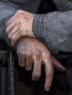 a man's hands are covered in mud