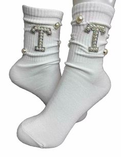 Elevate your sock game with these stunning women's socks. The T initial pearl and white rhinestone design is perfect for adding a touch of elegance to any outfit. Made with high-quality materials and handcrafted with care, these crew socks are both comfortable and stylish. The mid-calf length and size 6-10 fit make them a versatile option for any woman's wardrobe. Whether you're dressing up for a special occasion or just want to add some sparkle to your everyday look, these socks are the perfect choice. Bling Socks, T Initial, Sock Game, Women's Socks, White Rhinestone, Rhinestone Designs, Letter A, Womens Casual, Women's Wardrobe