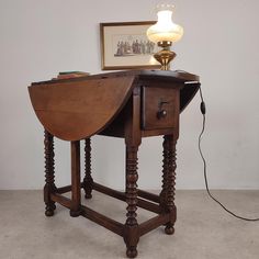 an old wooden table with a lamp on top