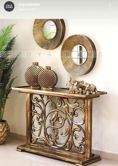 two mirrors on the wall above a console table