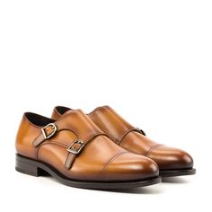 a pair of brown shoes with two buckles on the front and one in the back