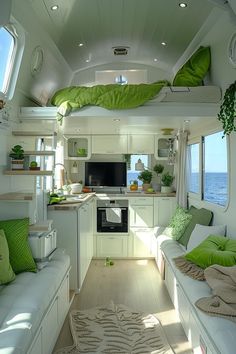 the interior of a camper with white walls and green pillows on the couches