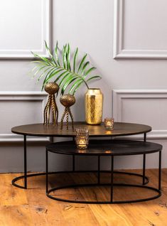 a coffee table with two candles and a potted plant sitting on top of it