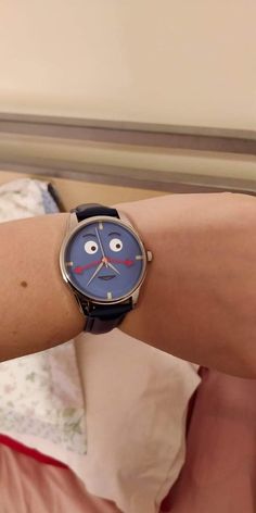 a woman's arm with a watch on it that has a face drawn on it