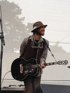 a man standing next to a guitar on top of a stage