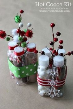 two small bottles filled with candy canes and christmas decorations sitting on top of a table