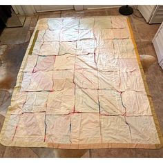 a kitchen area with a large quilt on the floor