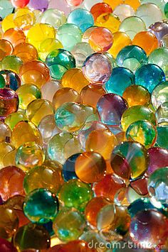 many different colored glass beads are stacked together