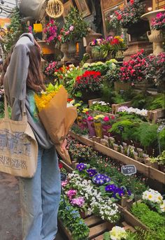 a woman carrying flowers in a flower shop