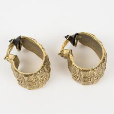 Stylish Yves Saint Laurent YSL Paris hoop clip-on earrings. They feature an oversized dimensional hoop shape with gilt metal all textured with a crocodile embossed pattern. The earrings are signed with the "YSL" pierced logo on the clasp. Pieces of that same collection were worn by Penelope Cruz in the 2017 movie "Loving Pablo," check the last pictures for reference. Measurements: 1.88 in high (4.7 cm) x 1.13 in wide (2.9 cm) x 1.25 in deep (3.2 cm).  Please see the measurements noted above in t Ysl Paris, Embossed Pattern, Penelope Cruz, Crocodile Pattern, Modern Branding, Best Wear, Clip Earrings, Clip On Earrings, Yves Saint Laurent