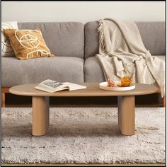 a coffee table sitting on top of a carpeted floor next to a gray couch