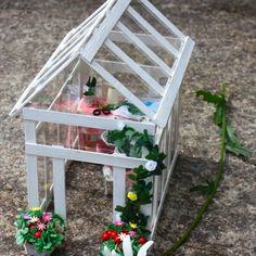 a doll house with flowers and plants in it