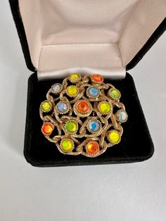 Vintage Sarah Coventry gold tone roped brooch intertwining 17 multicolored neon stones In blue, orange and yellow. Marked ©️SARAH COV Excellent pre loved condition. This listing contains photographs of the actual item you will receive. Please look closely at the pictures in this listing as they are part of the product description. Please read the description, as any imperfections or condition comments will be included.  I urge you to please contact me with any and all questions. I am happy to provide more photos of the item on request. I'm still a newbie and getting the hang of photographing jewelry. Sarah Coventry Jewelry Vintage, Photographing Jewelry, Green Brooch, Triple Heart, Sarah Coventry Jewelry, Vintage Monet, Heart Brooch, Sarah Coventry, Pearl Brooch