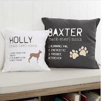 two black and white pillows on a bench in front of a bookcase with books