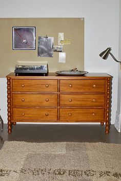 an old record player sits on top of a dresser