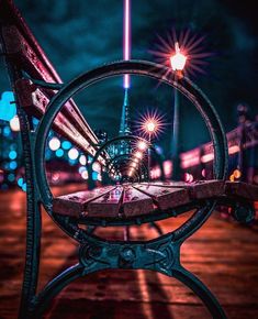 a bench sitting on top of a wooden floor next to a street light at night