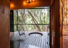 an outdoor hot tub in the middle of a deck with lights hanging from it's ceiling