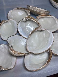 several oysters sitting on a table next to a plate with an empty bowl in the middle