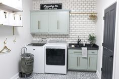 a laundry room with washer and dryer next to each other in front of a brick wall