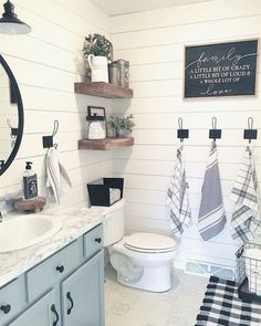 the bathroom is decorated in white and black with plaid towels hanging on the rack above the toilet