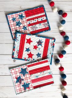 two red, white and blue patriotic placemats with pom - poms