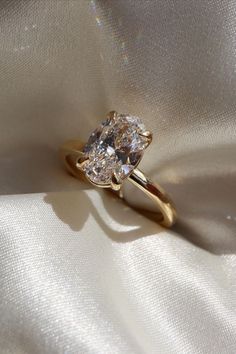 a diamond ring sitting on top of a white cloth