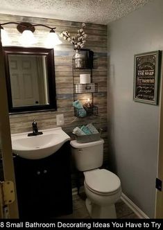 a small bathroom decorated in shades of gray and white with wood accenting the walls