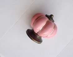 an antique pink door knob on a white tile floor