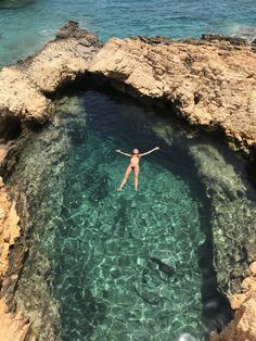 a woman is swimming in the clear blue water