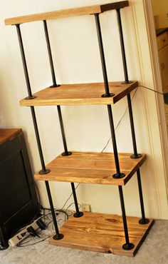 a wooden shelf with metal pipes and wood shelves on it's sides in a living room