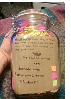 a hand holding a jar filled with colorful sticky notes and writing on the inside of it