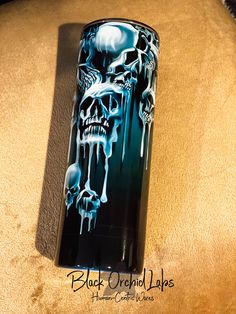 a lighter with skulls painted on it sitting on a table