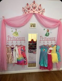 a room with princess dresses hanging on the wall