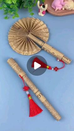 two bamboo sticks with red tassels next to each other on a blue surface