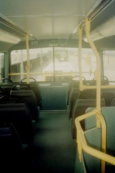 the interior of a public transit bus with yellow handrails and seats on both sides