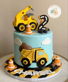 a blue and yellow cake with construction vehicles on it