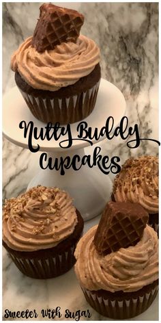 three chocolate cupcakes with peanut butter frosting on top and the words, nutty buddyy cupcakes