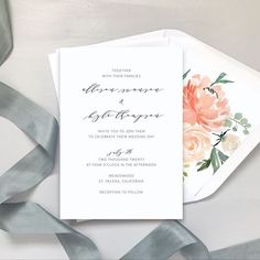 a wedding card with flowers on it next to some silver ribbons and grey satin ribbon