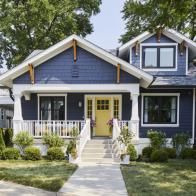 a blue house with white trim and two front porches on the first floor is shown