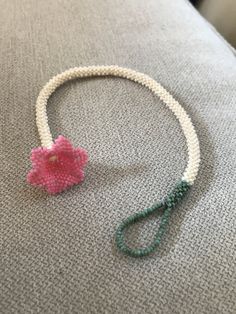 a beaded bracelet with a pink flower on it