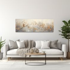 a living room with white furniture and large painting on the wall above it's couch