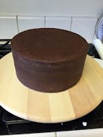 a chocolate cake sitting on top of a wooden board in the middle of a stove