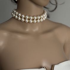 Add a touch of timeless elegance to your jewellery collection with this stunning White Shell Pearls Necklace with 2 layers of 12mm pearls and luxurious gold rhinestones. Each glossy bead is crafted to mimic the radiant beauty of real pearls, creating a sophisticated and versatile piece. They are luxurious, heavy and cold, just like the real ones. Materials: 12mm Shell Pearls, gold rhinestones, gold plated stainless steel clasp Shell pearls are made from crushed shells. Oyster shells are cut and transformed into powder and then reformed into perfect pearl shape with an infinite shine.  They are very popular as a natural alternative to expensive pearls.  Available lengths: - 12 inches/30.5cm  - 12.5 inches/31.7cm  - 13 inches/33cm  - 13.5 inches/34.3cm  - 14 inches/35.5cm  - 14.5 inches/36.8 Elegant White Pearl Charm Choker, Elegant White Choker With Pearl Charm, Formal Pearl Choker With Pearl Charm, Elegant Pearl Drop Choker Jewelry, Elegant Pearl Drop Choker Necklace, Formal Pearl Choker With Pearl Drop, Elegant Pearl Chain Choker For Party, Elegant Pearl Embellished Choker Jewelry, Elegant White Pearl Drop Choker